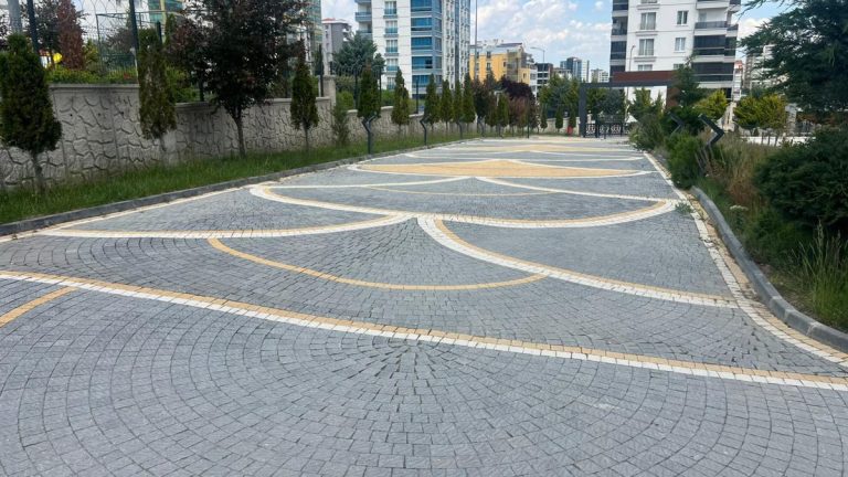 Ağaçlarla çevrili site yolunda desenli parke taşı döşeme
