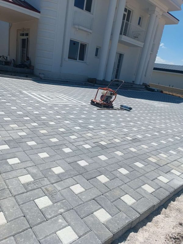 Villa bahçesinde açık gri ve beyaz parke taşı döşeme ile kompaktör