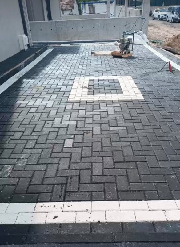 Balık sırtı dizilmiş antrasit parke taşı ve beyaz taşlarla kare desen